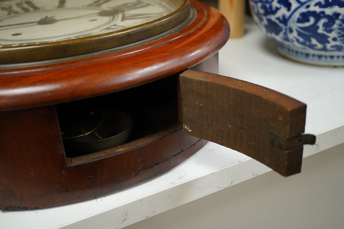 A mahogany wall clock with Roman numeral dial, with pendulum, 38cm in diameter
